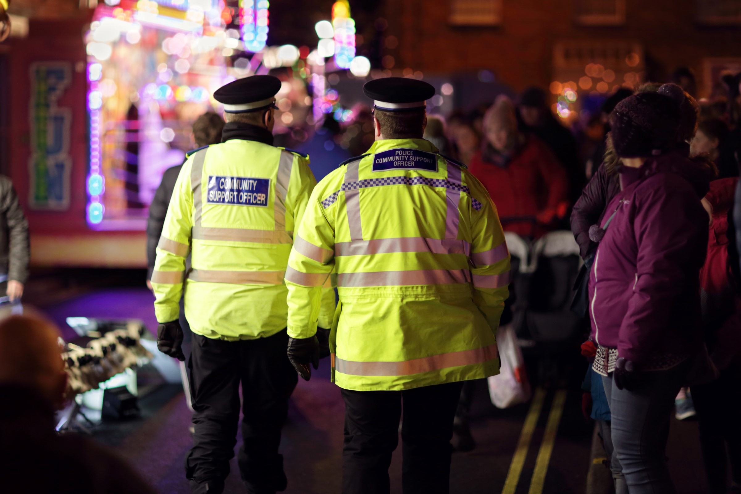 two police community support officers in a night scene