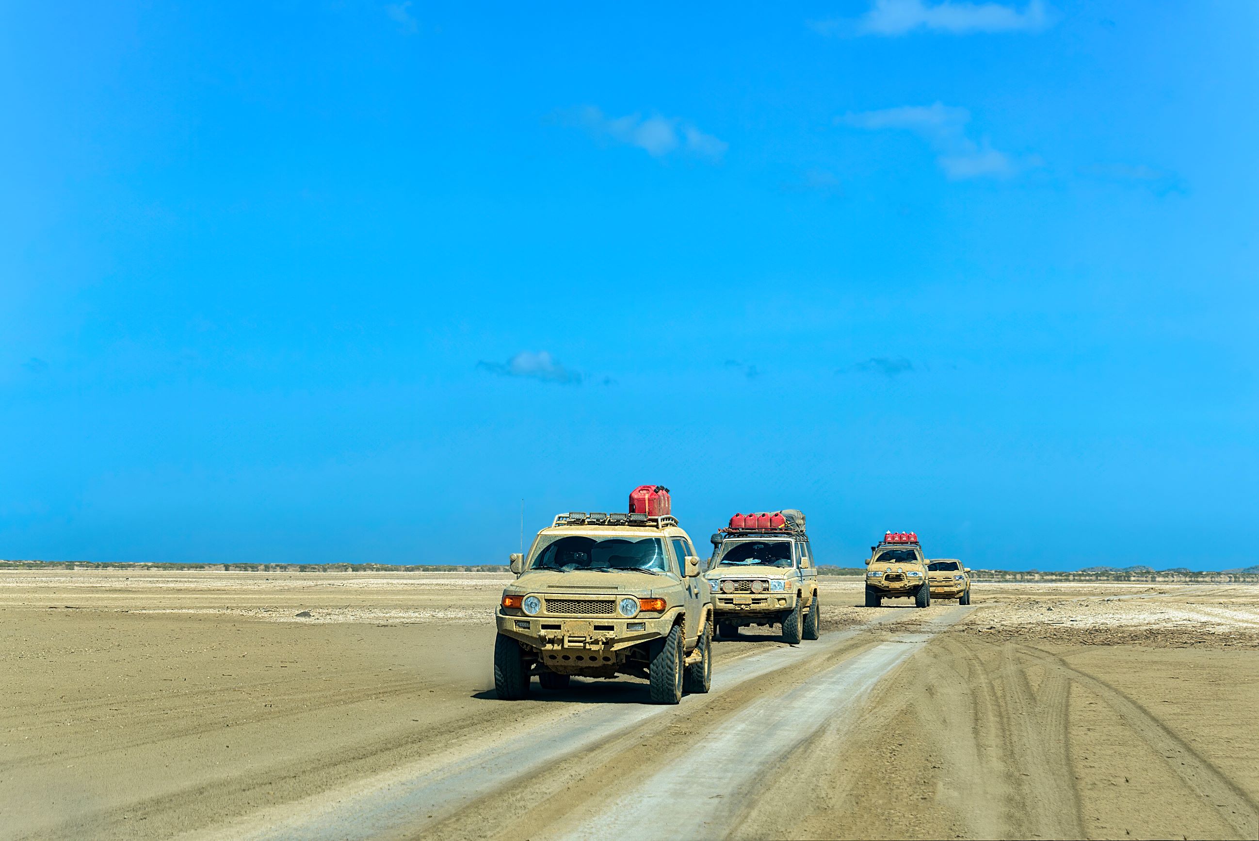 trucks in a convoy in the desert terrain