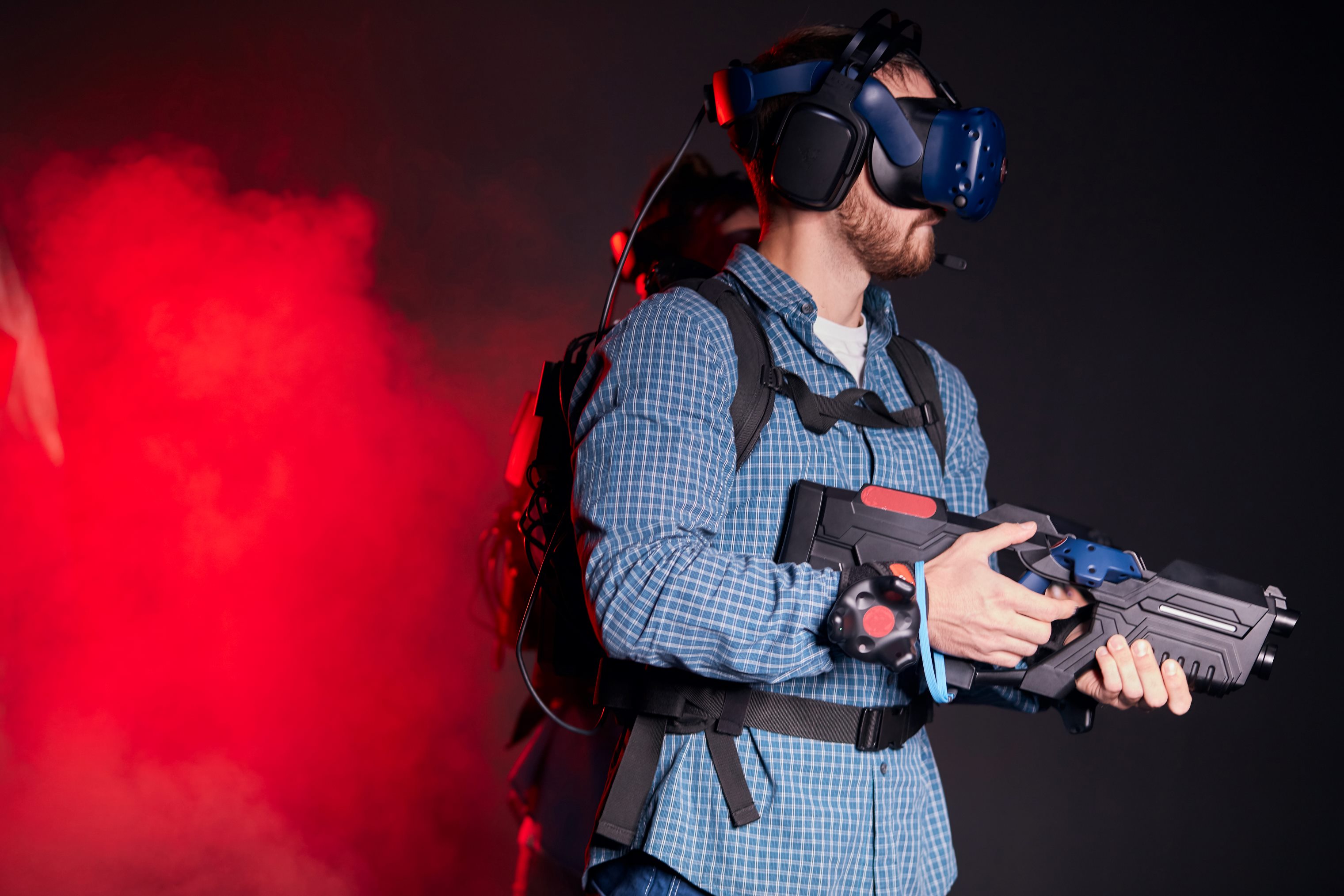 man wearing virtual reality glasses holding prototype gun