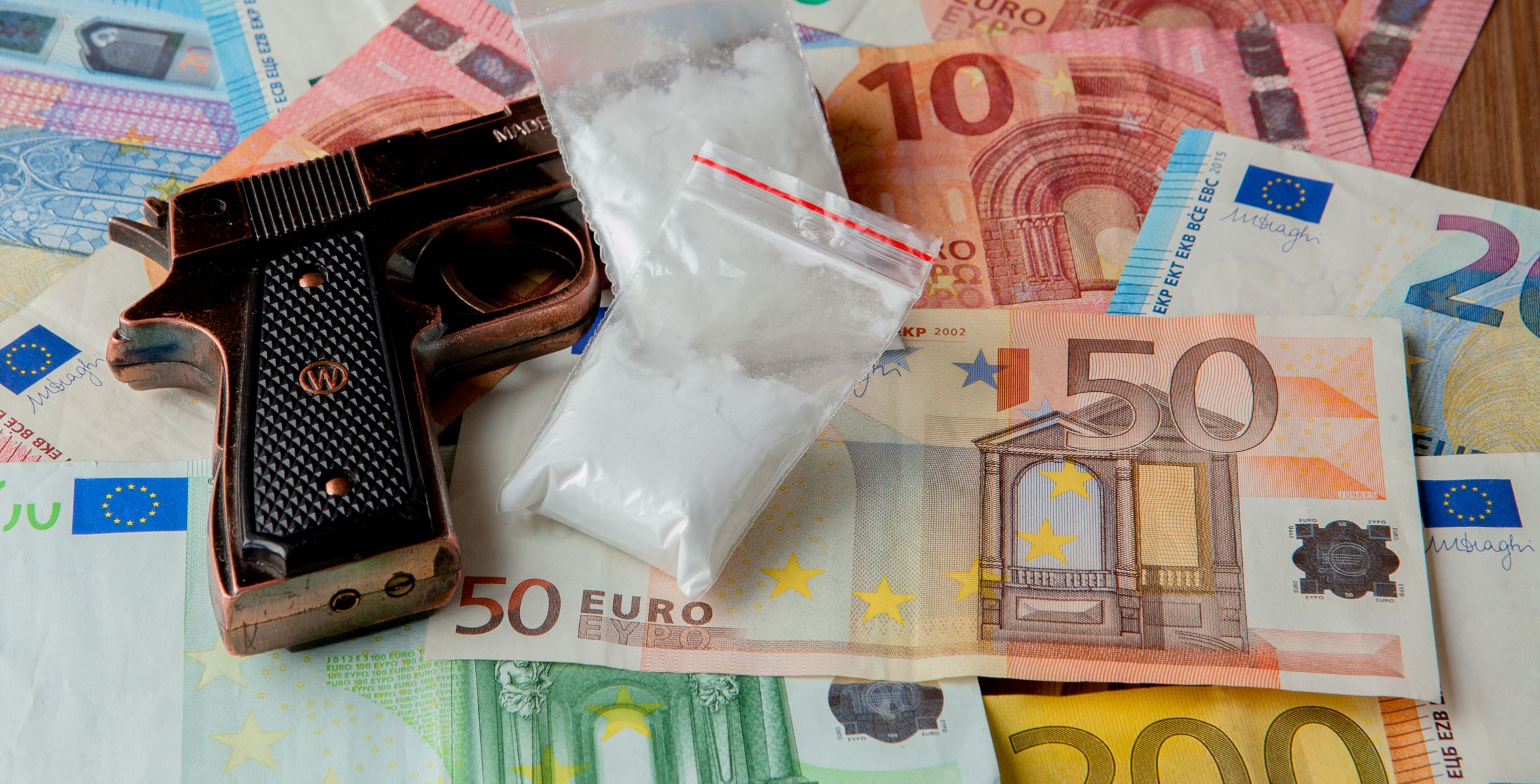 euro notest with a handgun and white powder in a clear bag