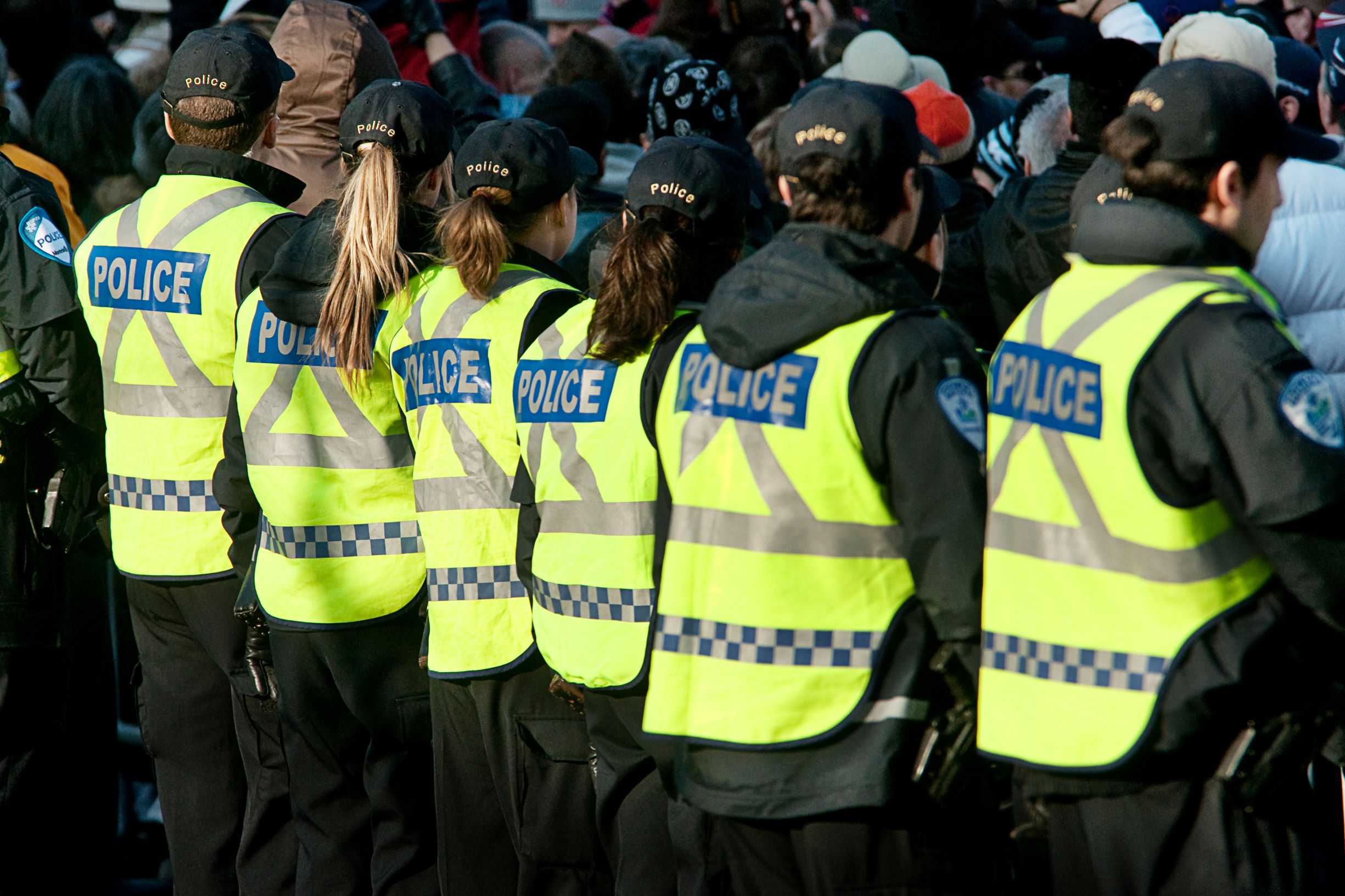 police officers in a line managing a crowd