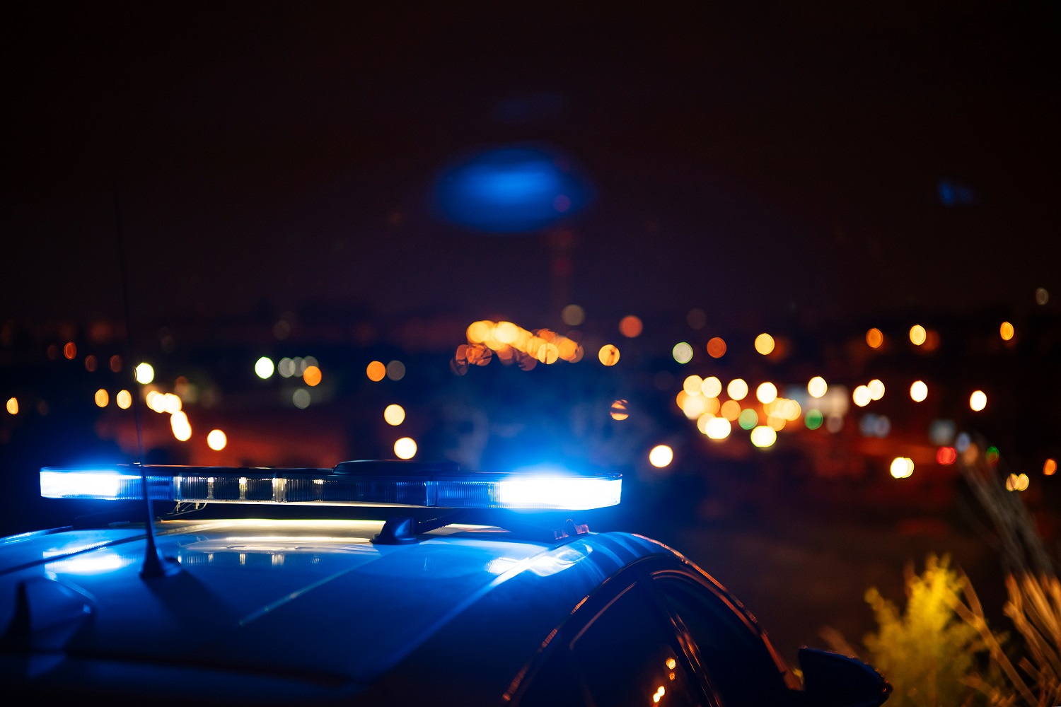 Police patrol car with blue lights at nightime.